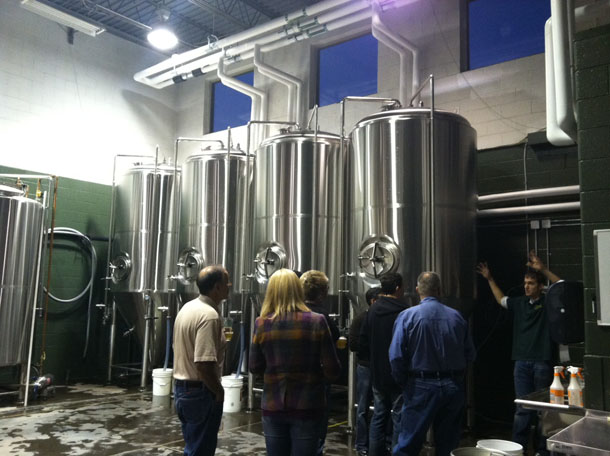 Chris Ray (far right) shows off the COTU brewing set-up. 