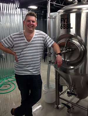 Hunter Smith of Champion Brewing Co. with the tank holding Lloyd's Revenge. (Photo by Lee Graves)