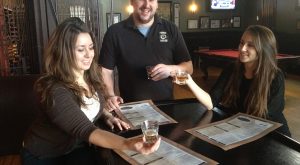 Brian Lawrence, general manager of Popkin Tavern, discusses the finer points of a Goose Island beer with staffers Elisabeth Reed (left) and her sister Rebekah Reed.