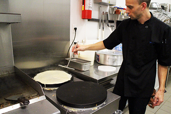 Kyle Keys spreads crepe batter at Les Crepes, which recently opened at Stony Point Fashion Park. Photos by Evelyn Rupert.