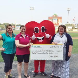 Rebecca Kuper (center) from M&T Bank’s Atlee branch, along with Cecilia Hodges , M&T Bank president of the Central and Southern Virginia market (right), presents a $12,500 check to Michelle McLees of the American Heart Association at the Richmond Flying Squirrels game on July 7th.