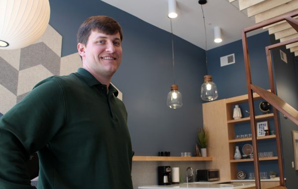 PJ Wallin in Atlas Financial's 550-square-foot office space, designed by Campfire & Co. and set to expand into an adjacent apartment. (Jonathan Spiers)