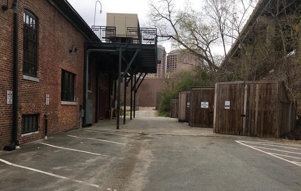 NFA claims the parking spaces (left), dumpsters (right) and the above HVAC deck are obstructing access to their property ahead. (J. Elias O'Neal)