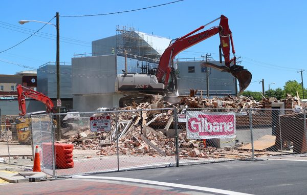 Demolition crews take down a building to make way for parking for the ICA, visible in the background. (Jonathan Spiers)