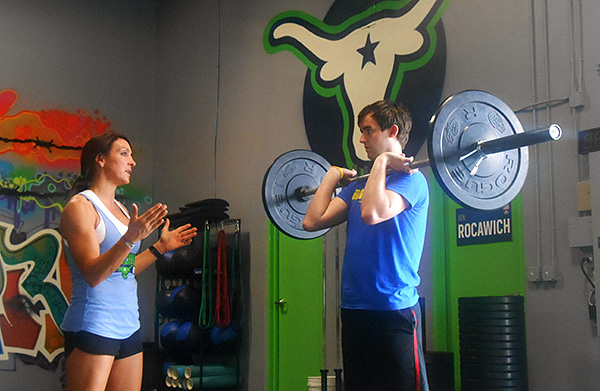 Stockyard CrossFit co-founder Lindsey Burnette coaches a client. (Photos by Burl Rolett)