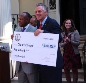 McAuliffe presents Jones with a ceremonial check for $5 million.